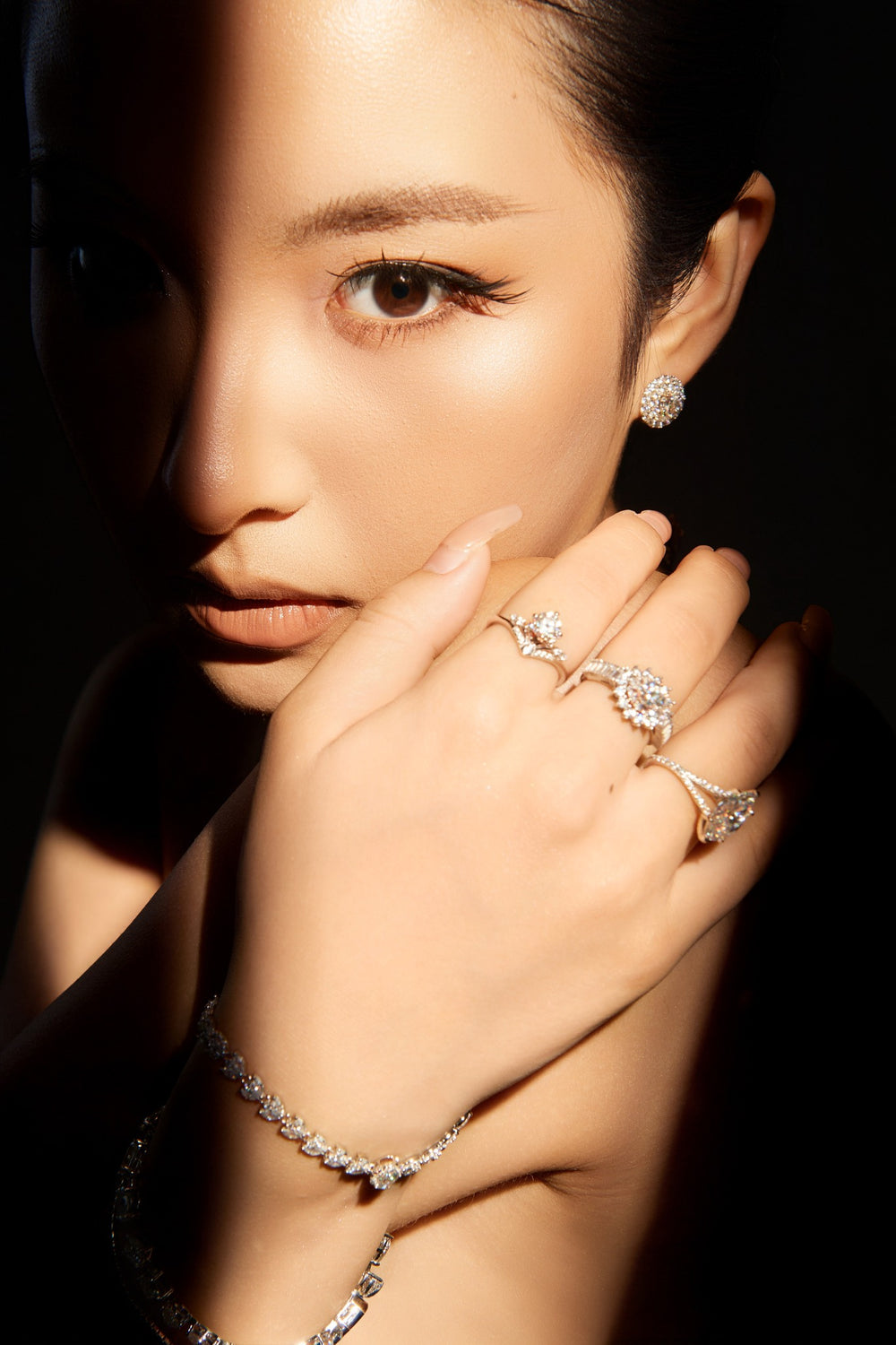 Người mẫu đeo nhẫn và vòng tay Moissanite Caterina Diamond, một vệt sáng qua gương mặt