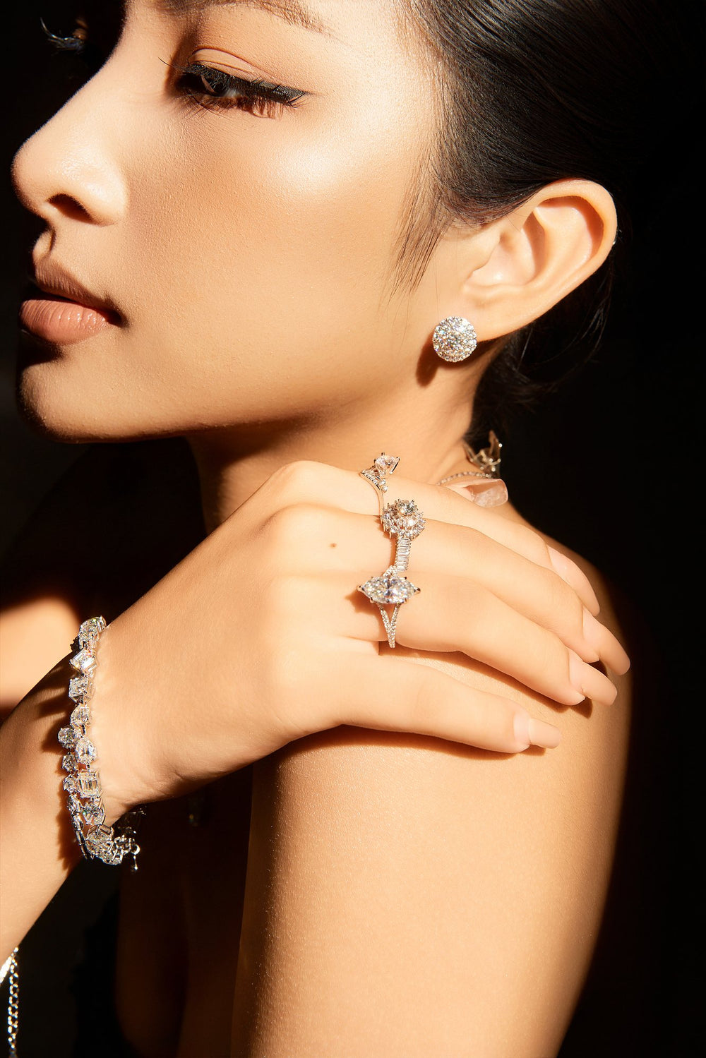 Khuyên tai, nhẫn và vòng tay Moissanite Caterina Diamond trong vùng sáng hẹp trên nền tối