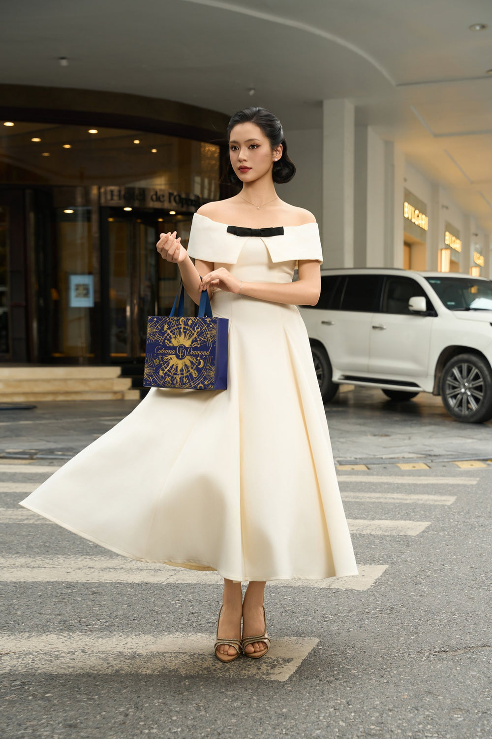 Cô ấy cầm túi quà Caterina Diamond xanh navy trên phố Hà Nội